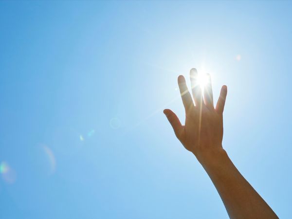 快晴の空に手をかざす様子