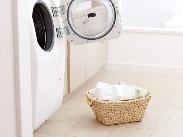 洗濯機の前に洗濯物が置かれている