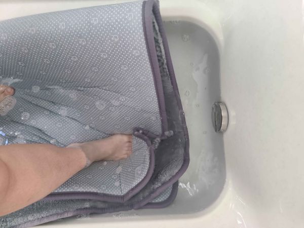 ラグを浴槽の中でお湯を張って踏み洗いをしている