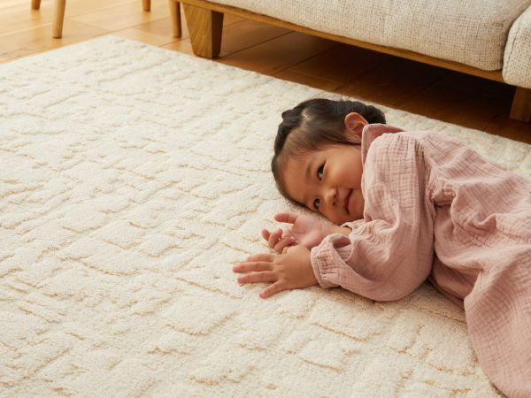 コットンラグに寝転ぶ少女