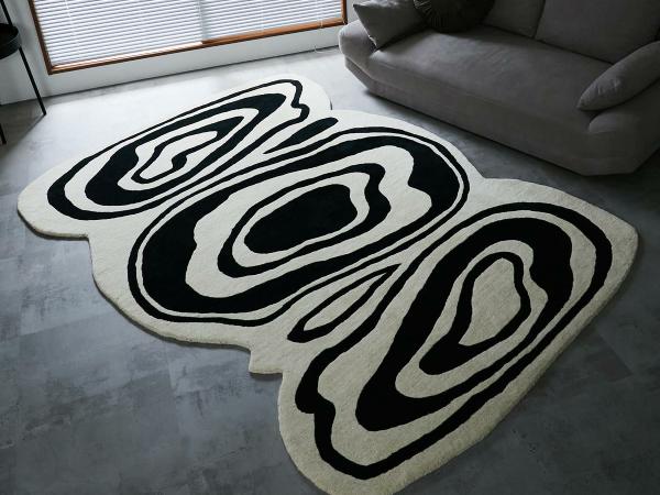 黒と白のデザインラグとグレーのソファ