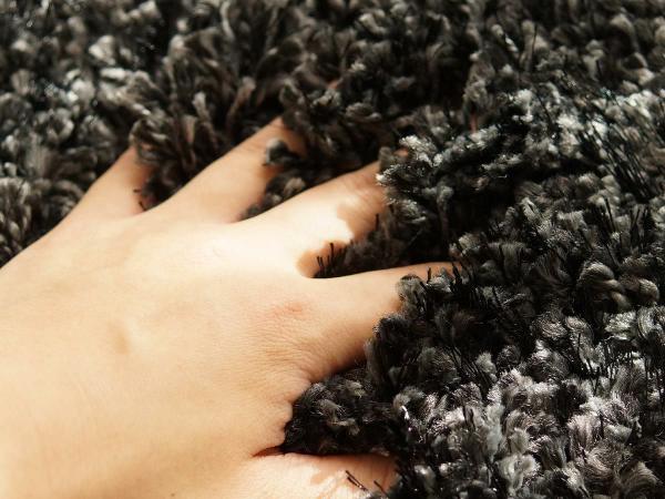 ミックスシャギーのブラックラグと手