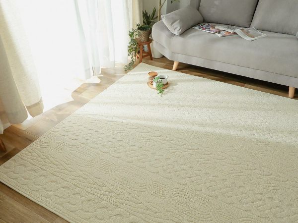 無地のアイボリーラグとグレーソファ