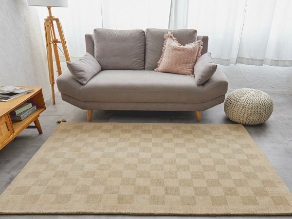 アイボリーのウール100%ラグとグレーのソファ