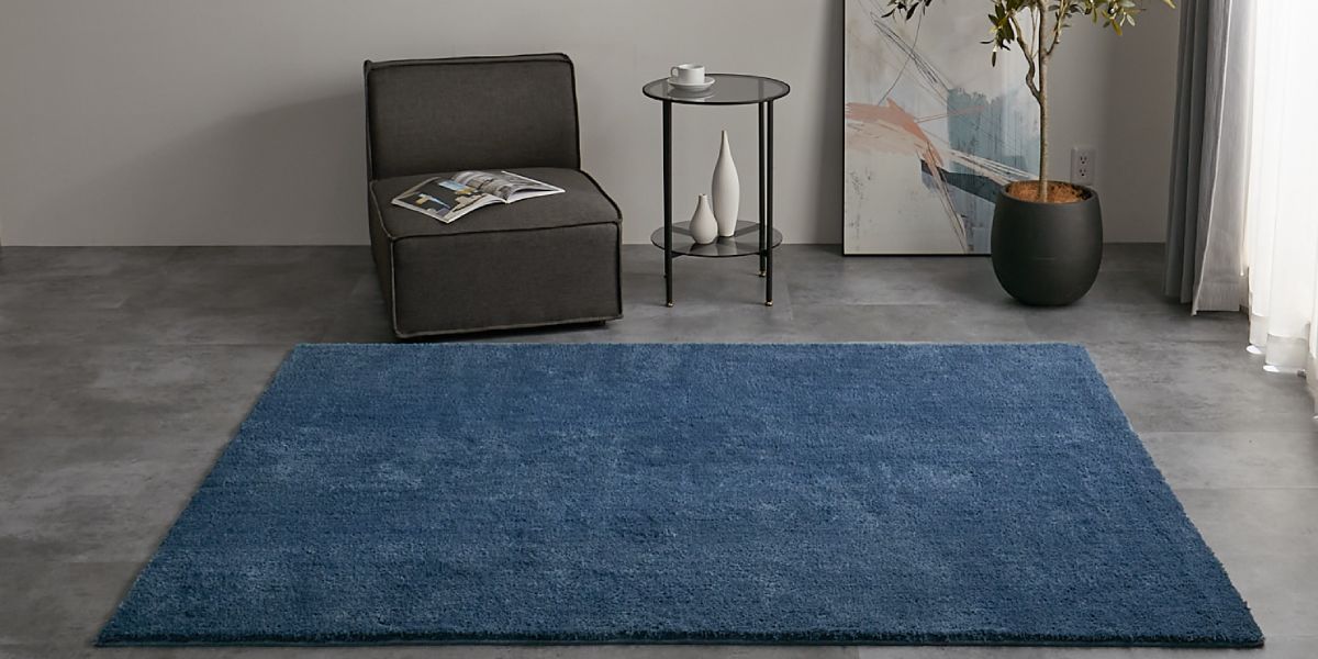 グレーソファとブルーのラグ