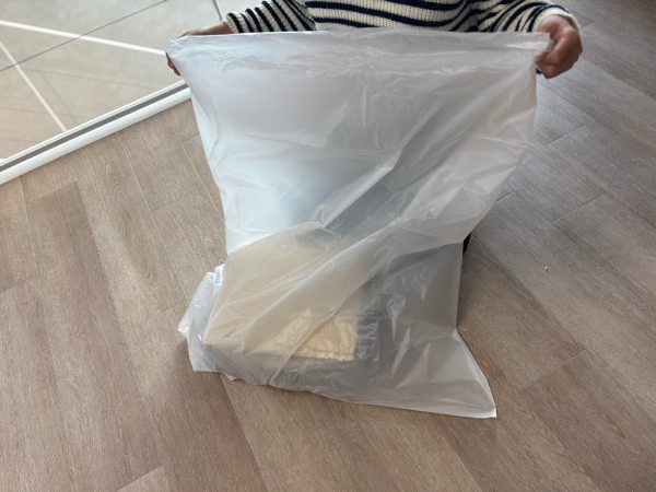 不要になったラグをゴミ袋に入れて捨てる