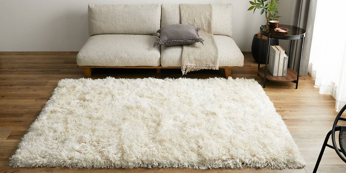 アイボリーラグとベージュのソファが映えるインテリア