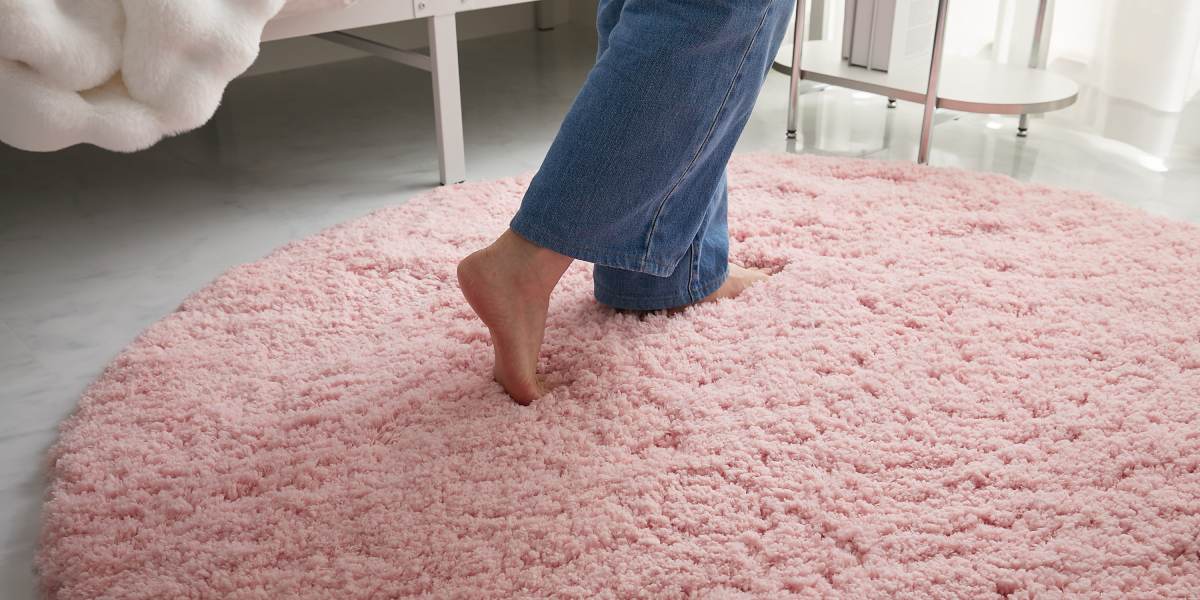 ピンクのラグ「ラフルーム」の上を歩く女性とナチュラルインテリア