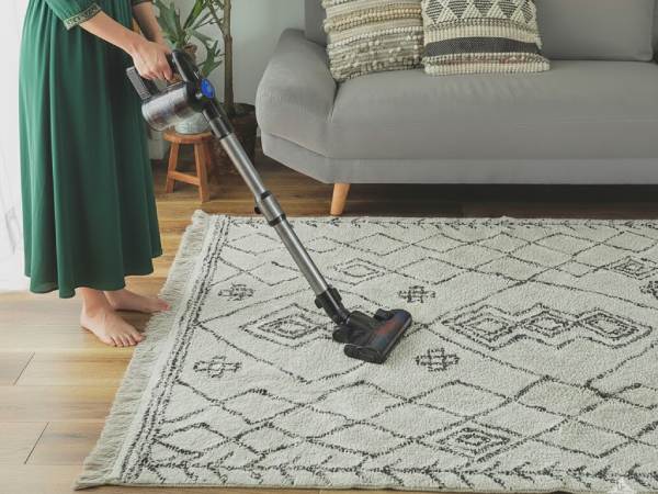 モロッカンラグを掃除機でお手入れする女性
