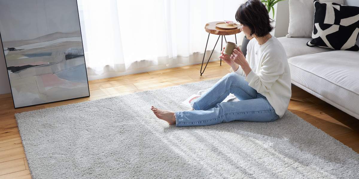 ポリエステル100％の洗濯できるラグの上でくつろぐ女性