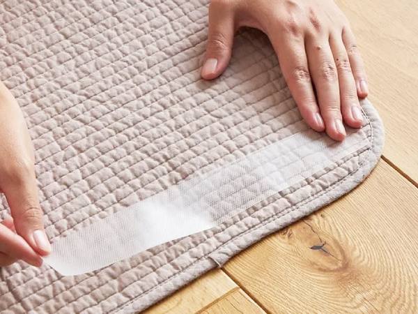薄くて滑りやすいラグを、滑り止めシールを使って固定する