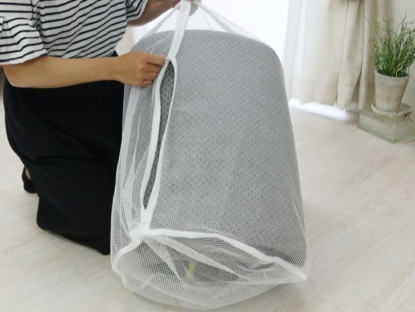 洗濯機で洗濯できるラグをネットに入れている