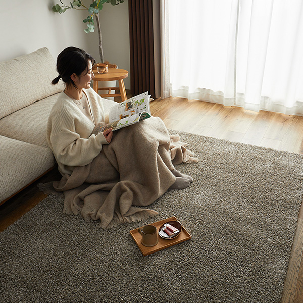 ラグ ティナの上に座って本を読んでいる様子