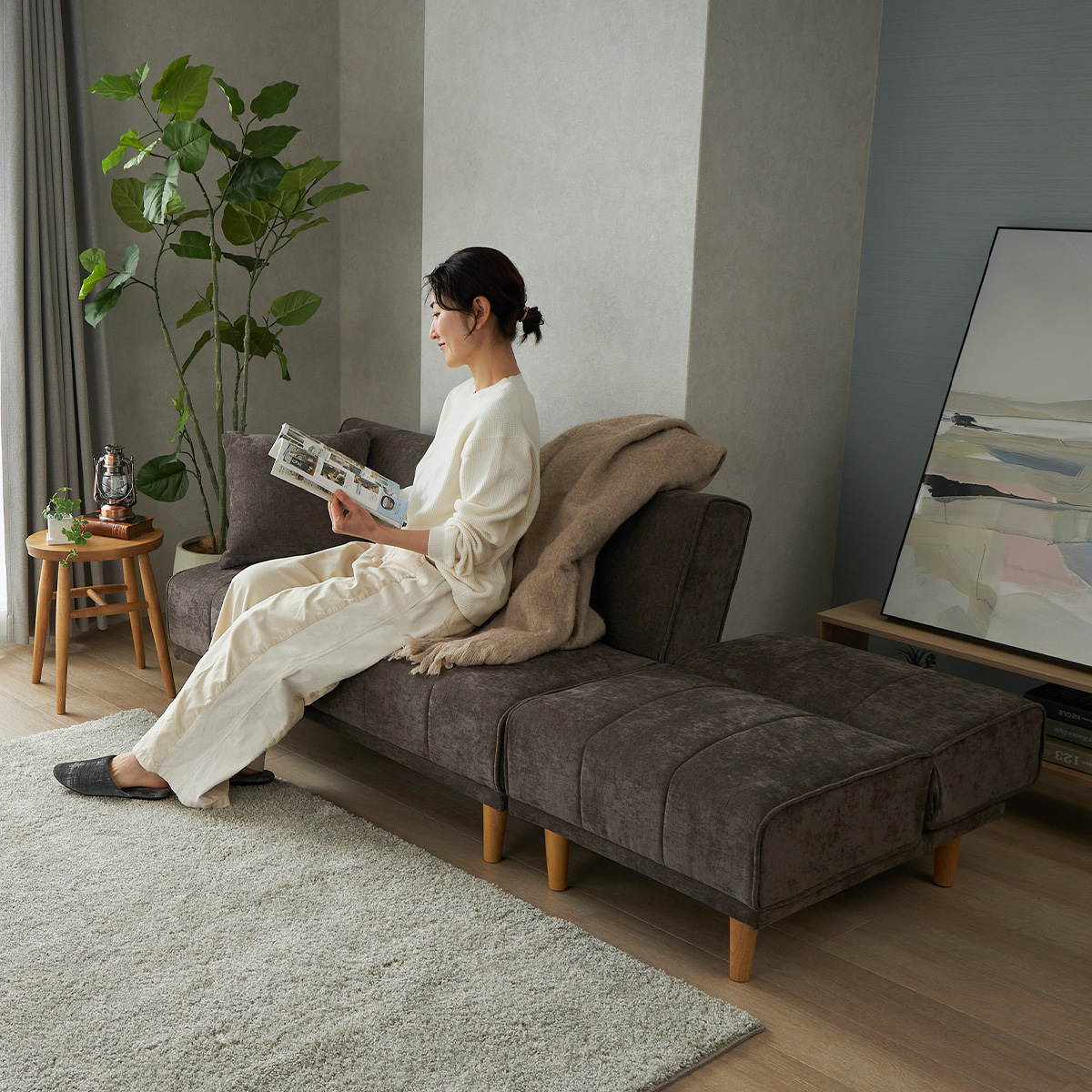 ブラウンの2人掛けソファに人が腰を掛けている様子